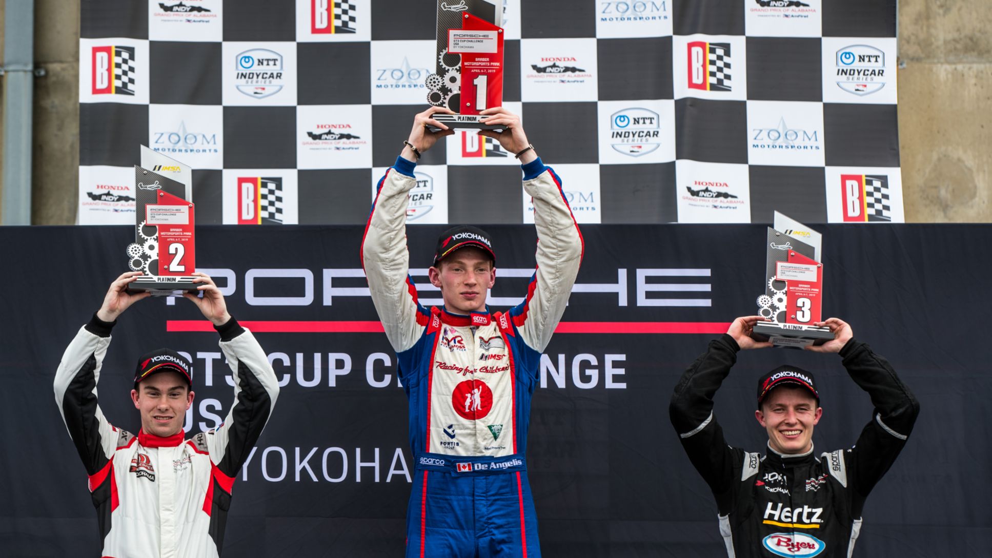 Roman DeAngelis celebrates Race 1 Win at Barber with Parker Thompson and Riley Dickinson